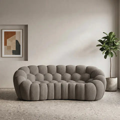 Boucle sofa with thick rounded cushions and padded arms, straight front view
