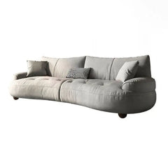 Curved sofa with rounded padded arms and soft-touch fabric, left-side view