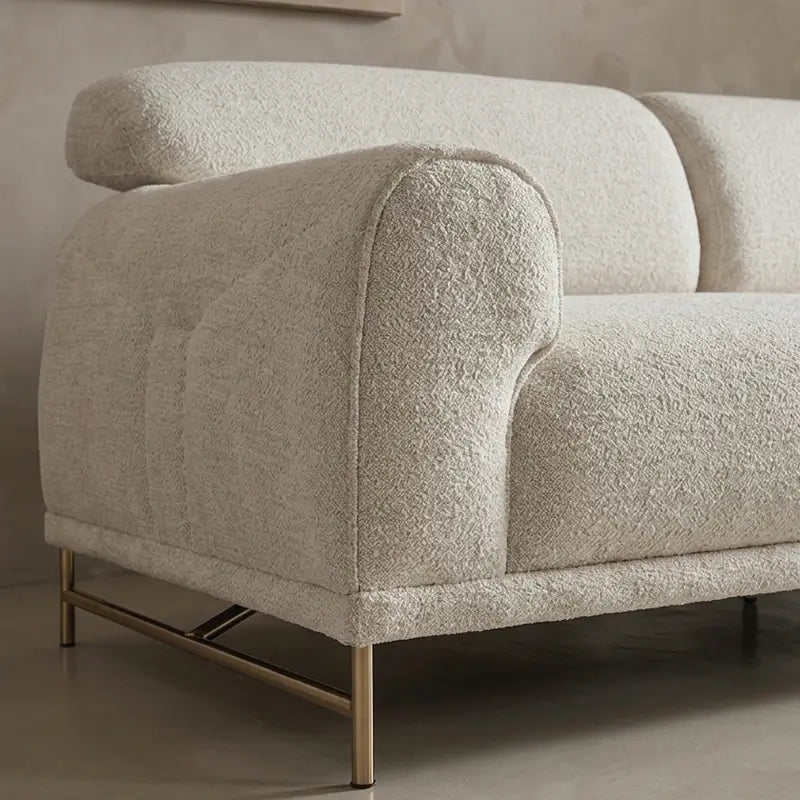 Boucle sofa with rounded cushioned arms and metallic legs, left-side view