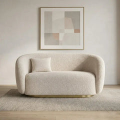 Boucle sofa with brushed gold base and rounded supportive arms, right-side view