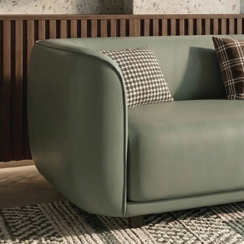 Curved sofa with soft rounded arms and low wraparound backrest, close-up of seat cushions