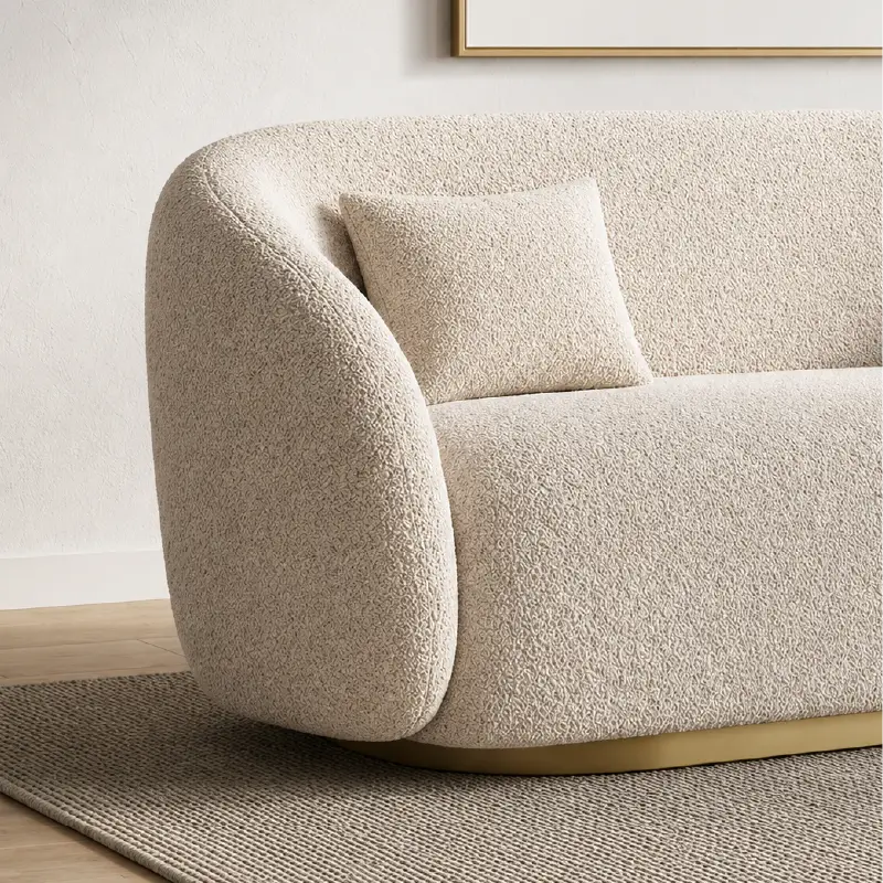 Curved sofa with brushed gold base and rounded supportive arms, full seating layout