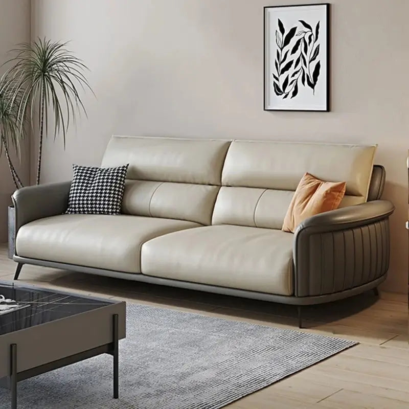 The sleek flared arms and stitched details lend it a settee-like elegance, while matte black metal legs give the piece an airy silhouette.