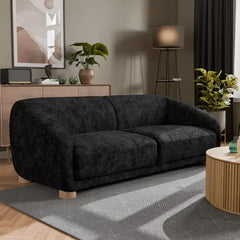 Boucle sofa with thick rounded arms and natural wooden legs, corner seating perspective