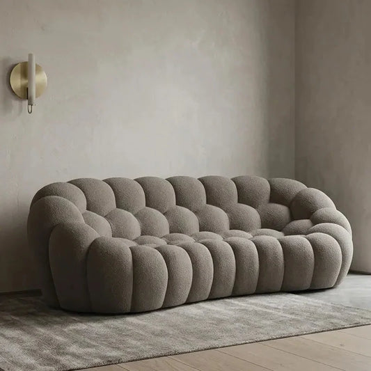 Lounge sofa with thick rounded cushions and padded arms, front three-quarter view
