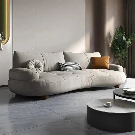 Curved sofa with rounded padded arms and soft-touch fabric, front three-quarter view