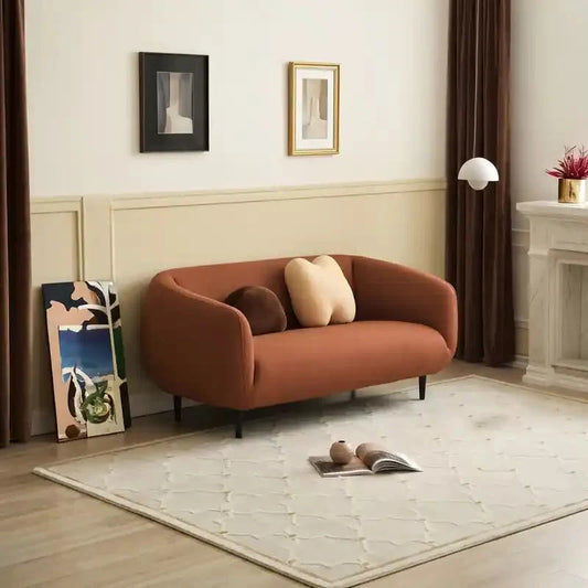 Curved sofa with wraparound backrest and compact seating, front three-quarter view