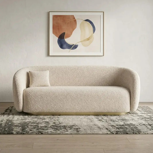 Boucle sofa with brushed gold base and rounded supportive arms, straight front view