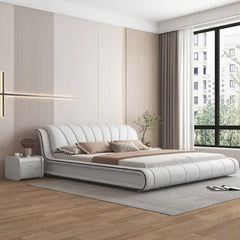 upholstered bed side view showing the upholstered frame and legs with curved padded headboard