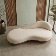 Lounge sofa with curved wooden base and asymmetrical backrest, left-side view