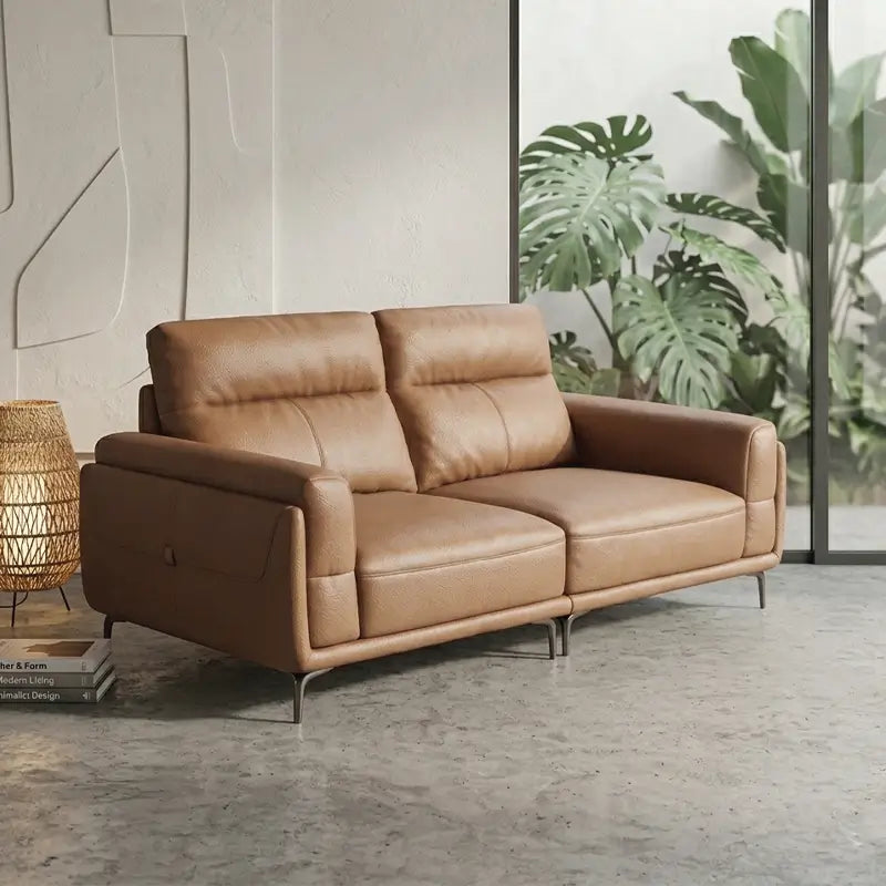 Leatherette sofa with wide padded arms and elevated metal legs, left-side view