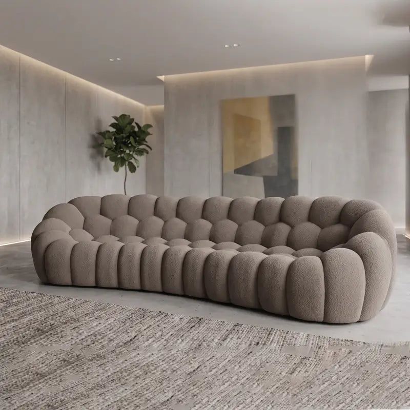 Lounge sofa with thick rounded cushions and padded arms, left-side view