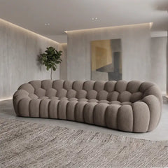 Lounge sofa with thick rounded cushions and padded arms, left-side view