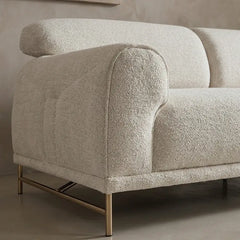 Boucle sofa with rounded cushioned arms and metallic legs, left-side view