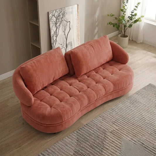 Upholstered in coral pink velvet-look fabric, this fabric sofa combines a modern sofa design with the relaxed proportions of a lounge sofa