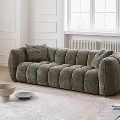 boucle sofa with side angle showing rounded arm support, upholstery close-up
