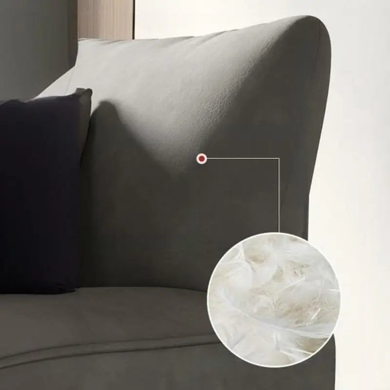 Curved sofa with rounded padded arms and soft-touch fabric, close-up of back cushions