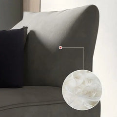 Curved sofa with rounded padded arms and soft-touch fabric, close-up of back cushions