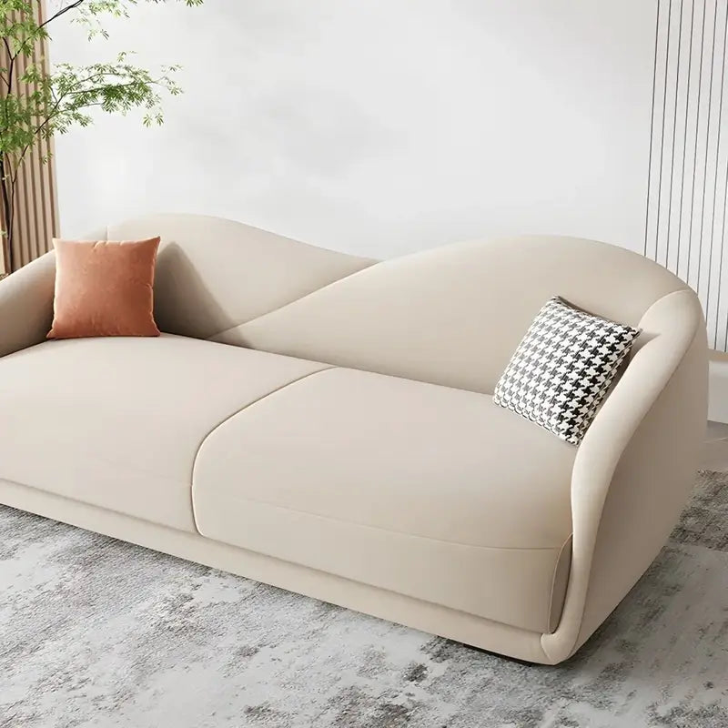 wave-shaped backrest, rounded wrap-around arms and low elongated form give it a soft sculptural look