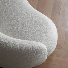 Curved sofa with wraparound backrest and deep bench seating, upholstery texture detail